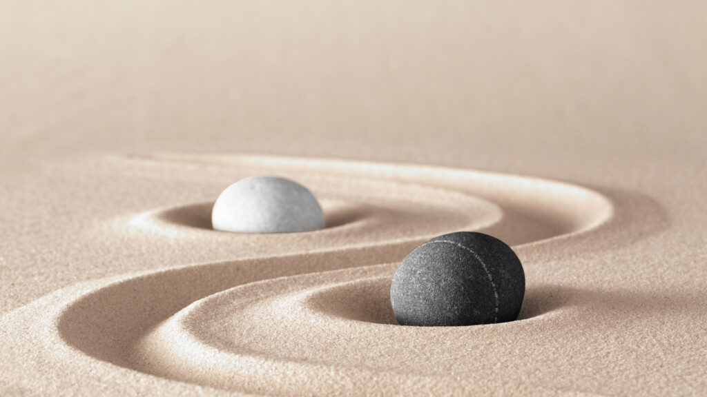 Zwei Steine im Sand versinnbildlichen das Yin und Yang